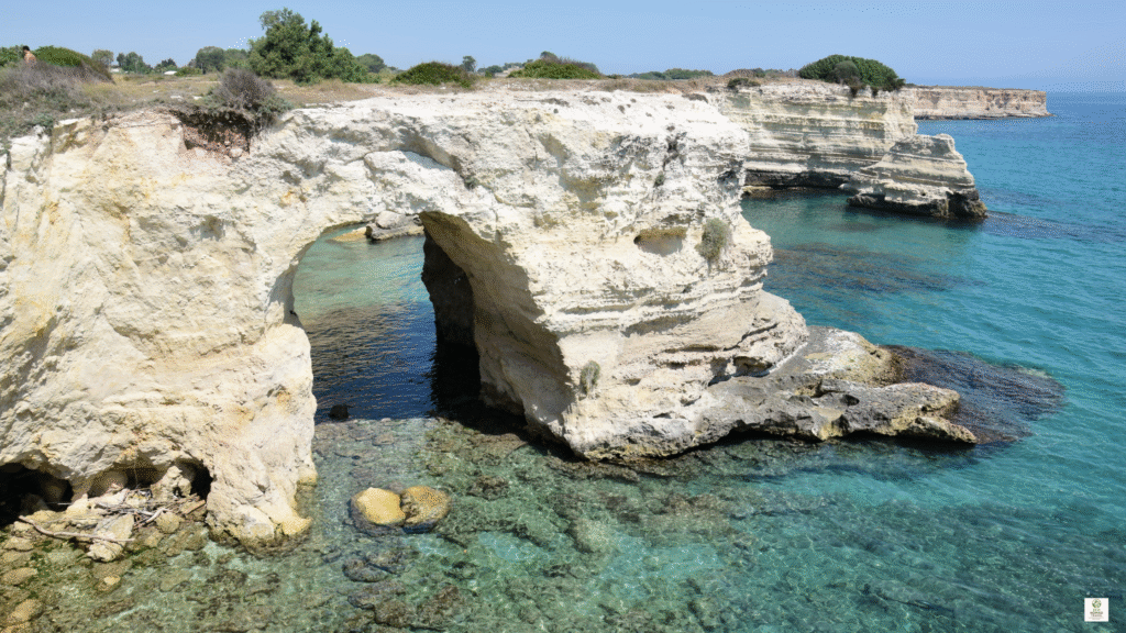 Rocky Adriatic coastline with a natural sea tunnel cut through the rock above clear water