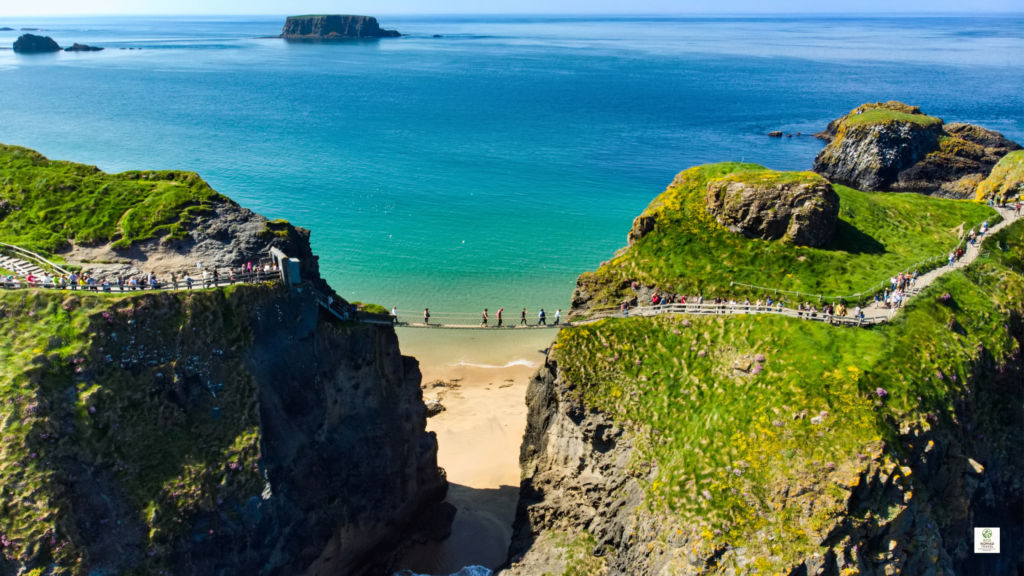 Cost of a trip to Ireland — Carrick-a-Rede Rope Bridge in Northern Ireland crossing rugged coastal cliffs above the Atlantic.